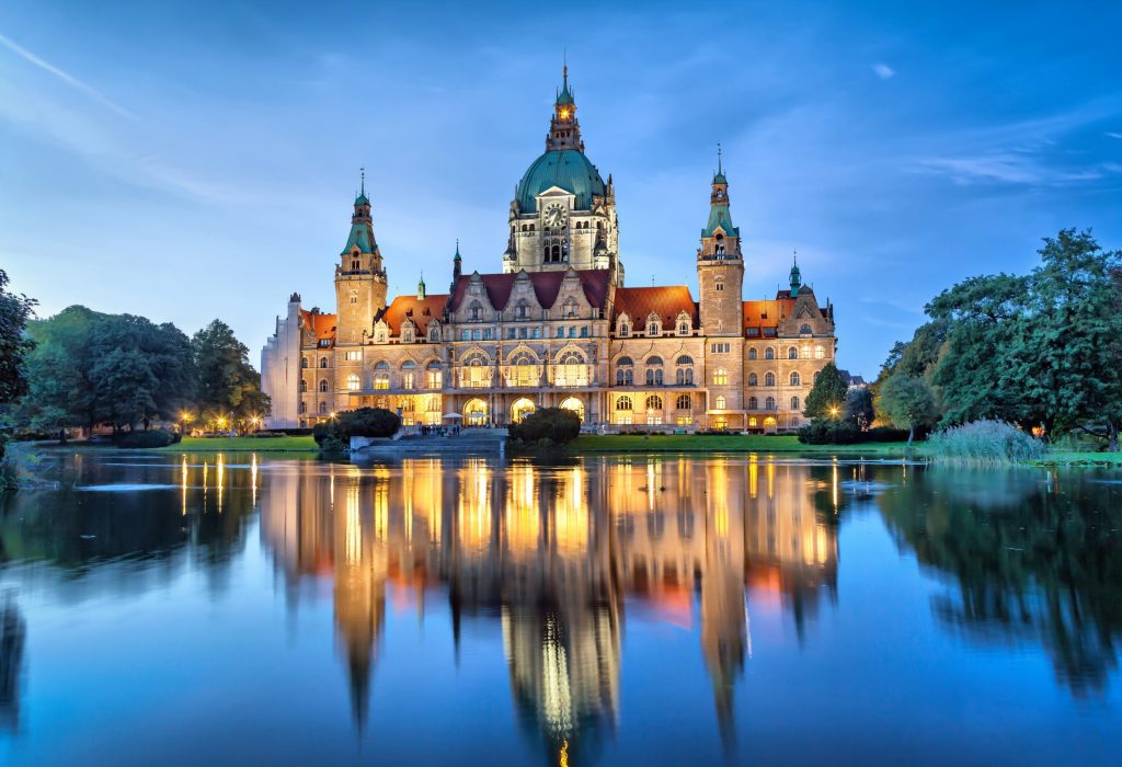 New City Hall of Hannover reflecting in water in the evening, Lower Saxony, Germany